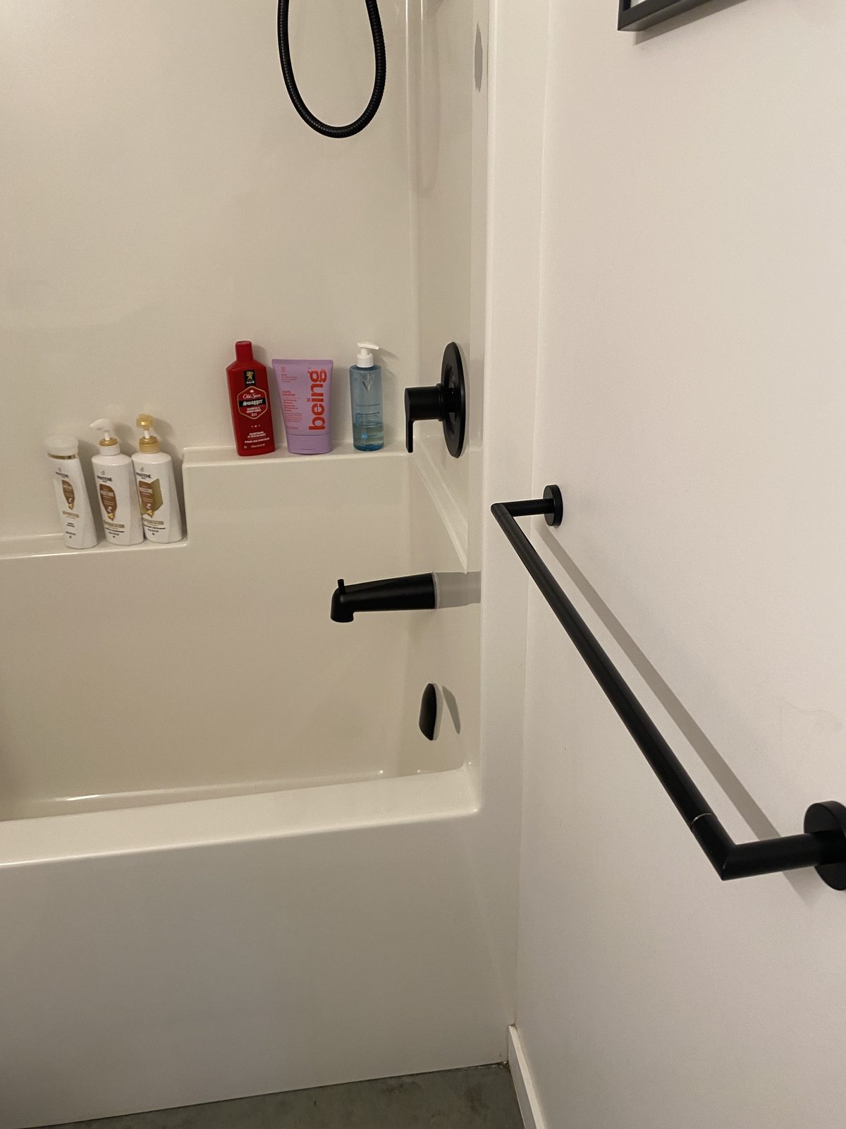 Close view of a freshly scrubbed tub with black fixtures, cleaned by Kendal
